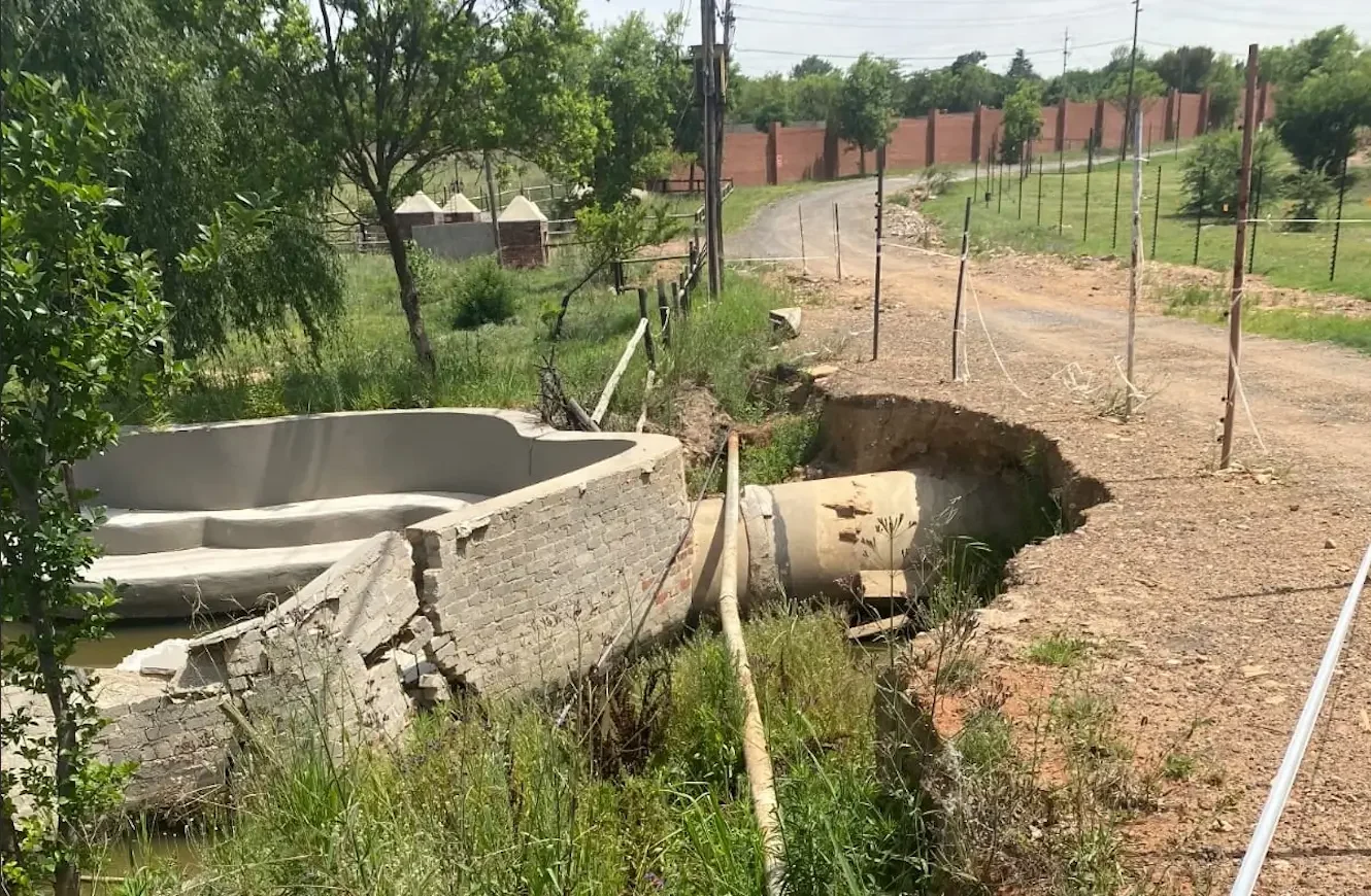 Damaged stormwater drainage system showing erosion and infrastructure failure near a rural road