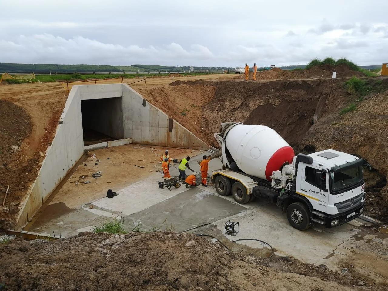 Workers and concrete mixer truck on a civil engineering project building a reinforced concrete structure and drainage system